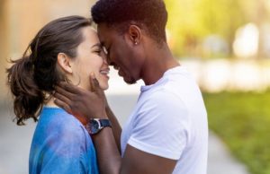 Multiracial young couple kissing outdoors