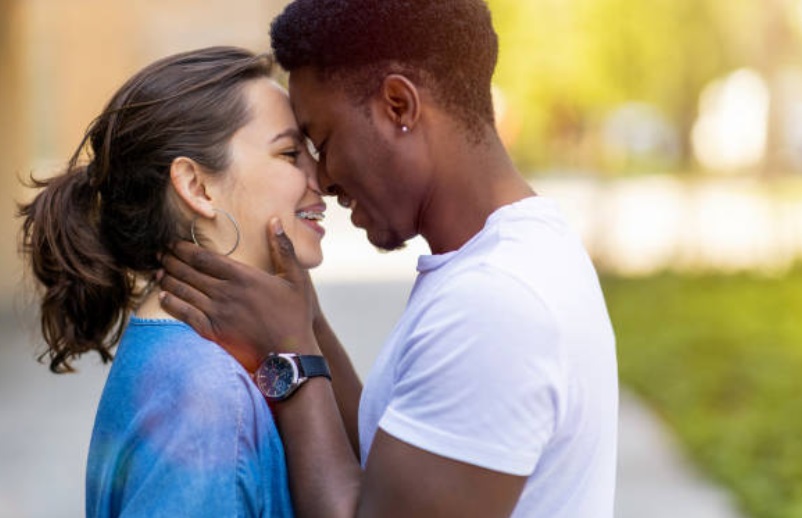 Multiracial young couple kissing outdoors